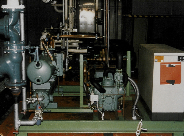 Eine komplexe Kälteanlage mit verschiedenen Rohren, Ventilen, Pumpen und einem Verdichter in einem technischen Raum. Eine komplexe Kälteanlage mit verschiedenen Rohren, Ventilen, Pumpen und einem Verdichter in einem technischen Raum.